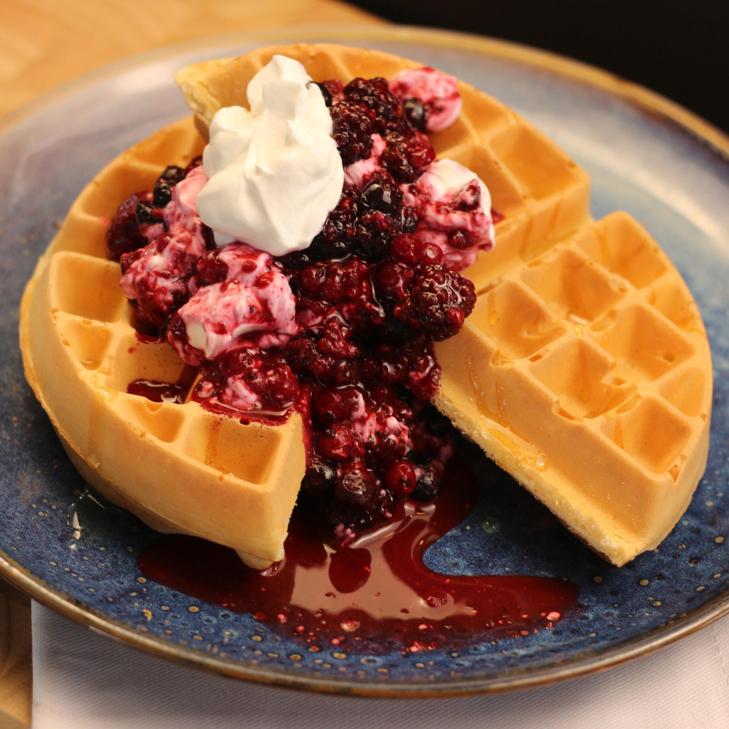 Breakfast berry waffle with yoghurt and honey on a plate