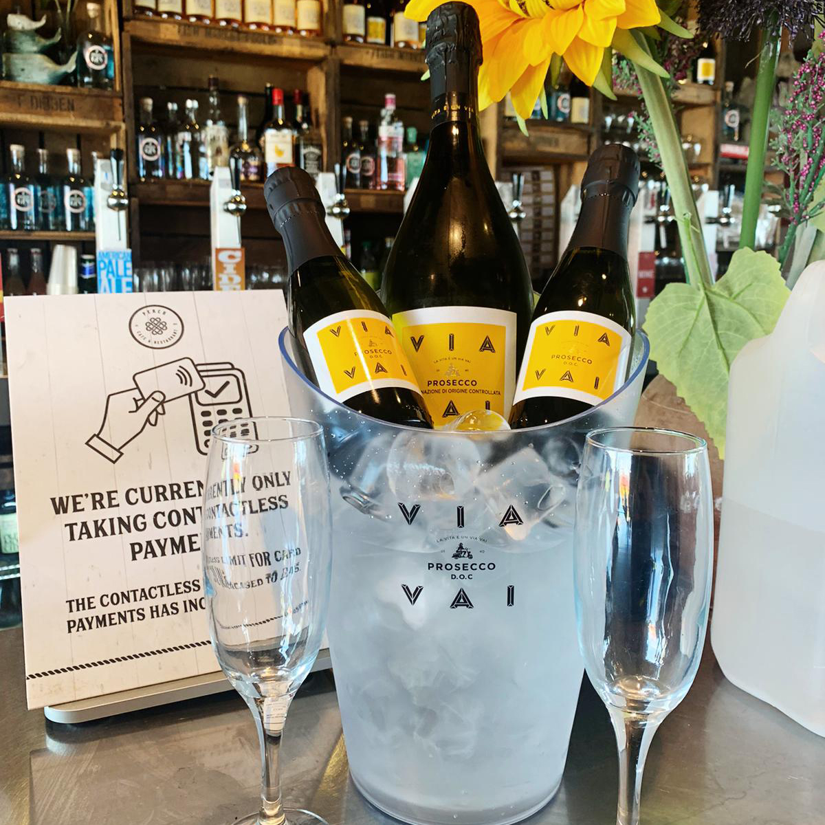 Bottles of Via Vai prosecco in a wine holder with ice and two prosecco glasses